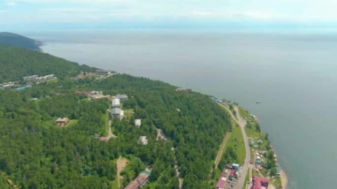 沿着河岸飞行。沿海建筑。绿色森林。水面。人与自然。无人机视频4k镜头。