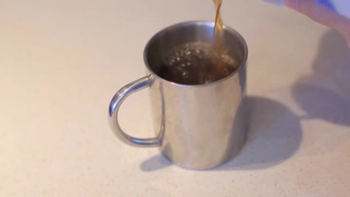将咖啡和牛奶倒入铁杯中。