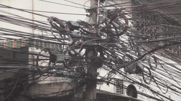泰国曼谷街道上乱七八糟的黑色电线，包括电线和电话通讯电缆。
