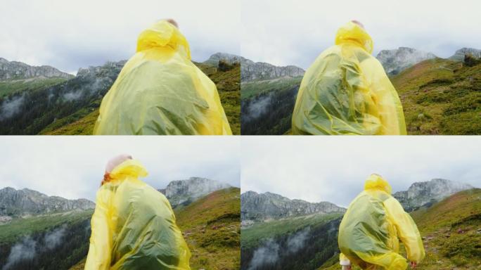 身穿黄色防水大衣的女子徒步欣赏山崖。