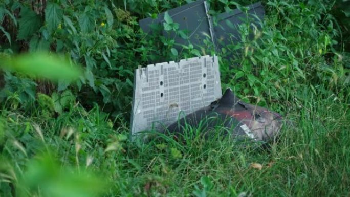 旧的CRT电视机垃圾被非法倾倒在灌木丛中