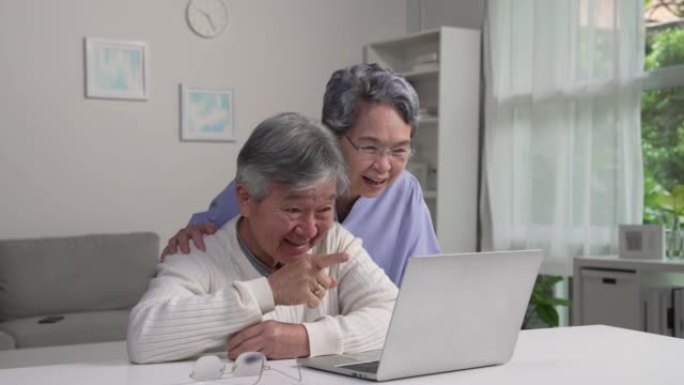 亚洲老年夫妇使用笔记本电脑进行视频通话会见朋友和家人。