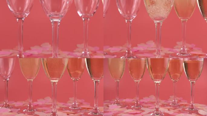 Sparkling wine is poured into glasses on a pink ba