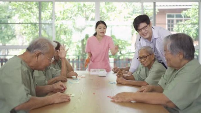 老年亚洲患者或养老金领取者的快乐群体肖像，护士和医生在疗养院玩游戏。高级生活方式活动娱乐。退休社区。