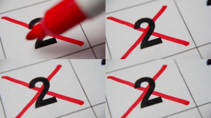 日历中的第2个数字在白纸上的宏中用红叉划掉。计划、笔记、会议日历。商业日历。日历中注释的标记。