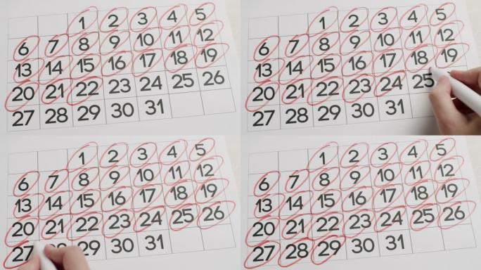 人的手在日历上写下第21、22、23、24、25、26、27、28、29、30、31天。