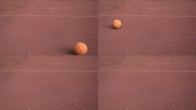 Basketball ball rolls through outdoor red street c