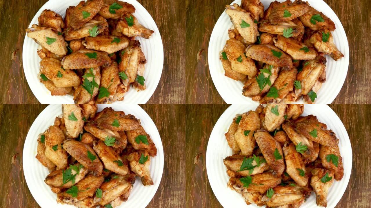 许多油炸的，撒上香菜，切成薄片的鸡翅在白盘中缓慢旋转。