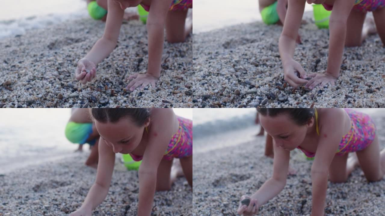 日落时，小男孩和女孩在海滩上捡石头