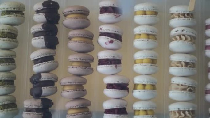 展示法国马卡龙糖果的俯视图，许多口味精致，甜蜜的诱惑。展示架上陈列着各种颜色的釉料饼干。