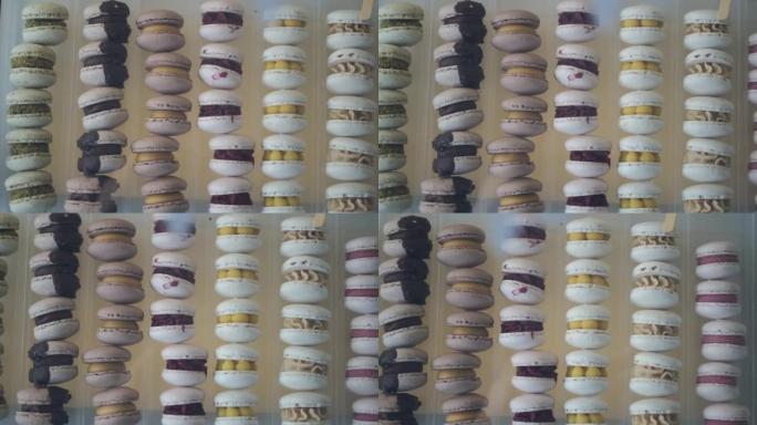 展示法国马卡龙糖果的俯视图，许多口味精致，甜蜜的诱惑。展示架上陈列着各种颜色的釉料饼干。