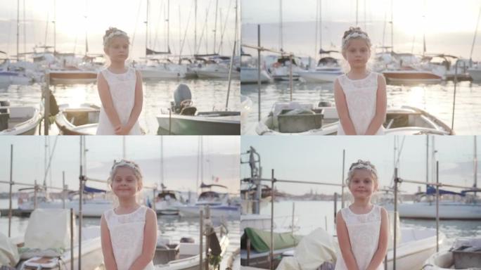 Little girl stops at sunset in front of the boats