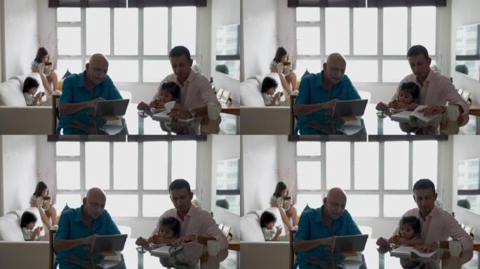 家庭生活 -- 一名印度男子照顾他蹒跚学步的孩子，而这名老人让自己忙于数字平板电脑