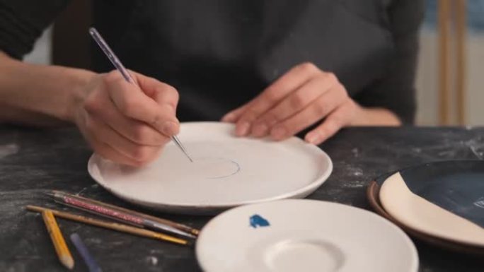 女人在盘子上画油图案