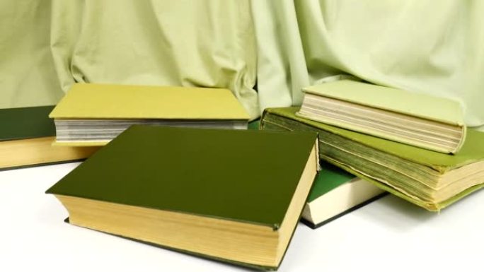 绿色的旧书在绿色织物的背景下