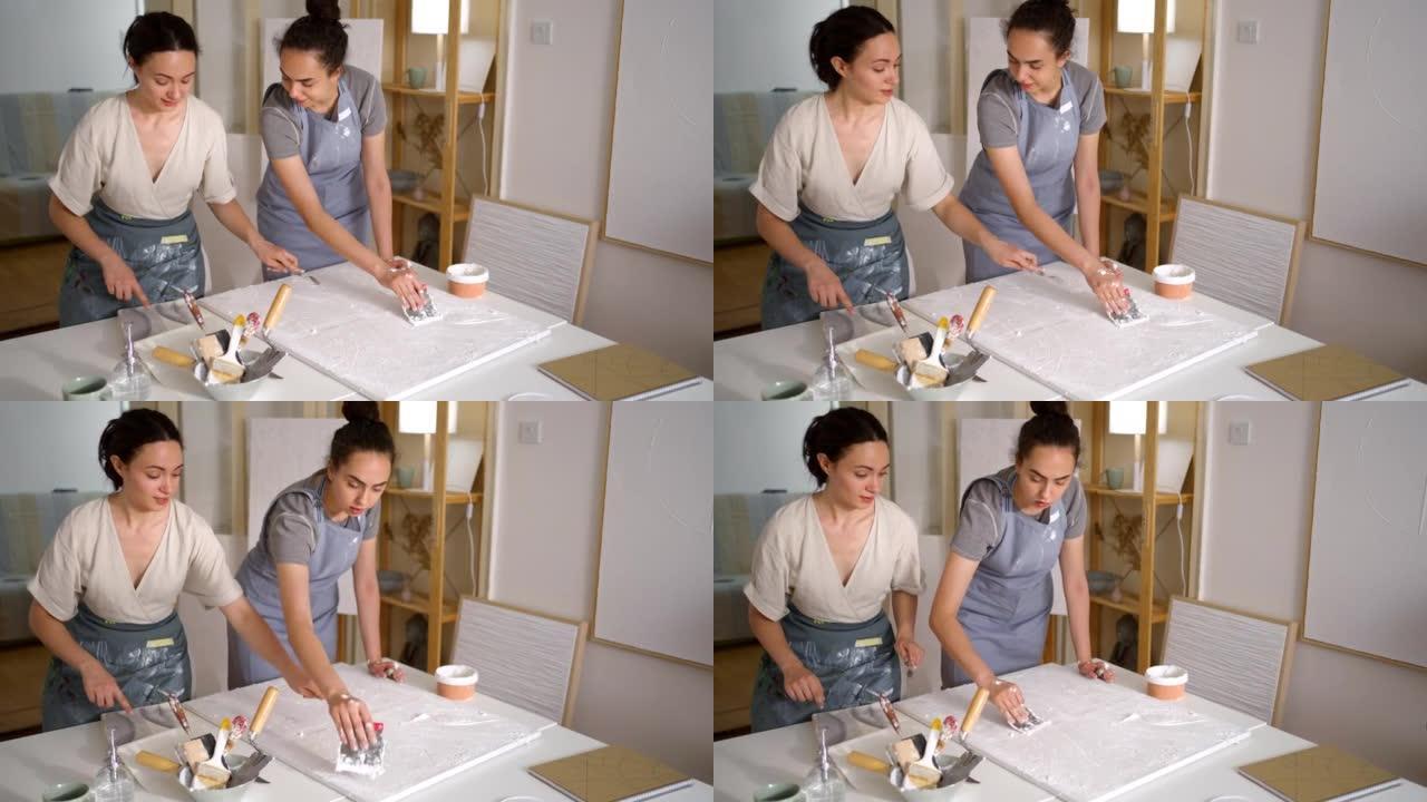 高加索姐妹，在他们的艺术工作室用画布上的丙烯酸腻子制作艺术作品