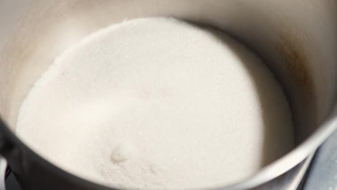 大量的糖倒入锅中，以便加热和融化，将其变成自制的焦糖
