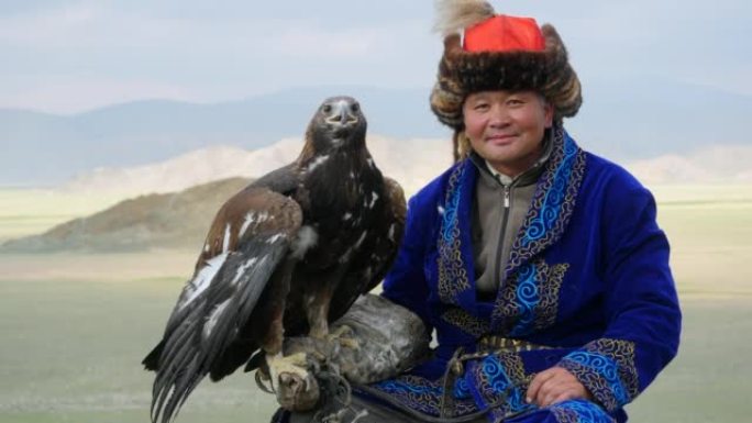 在西蒙古的巴扬-奥尔吉伊附近，身穿传统服装的哈萨克猎鹰者手臂上抱着一只金鹰