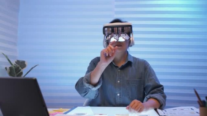 Ux ui开发人员在办公室晚上用增强现实眼镜全息图测试移动界面。增加设计的模拟空间