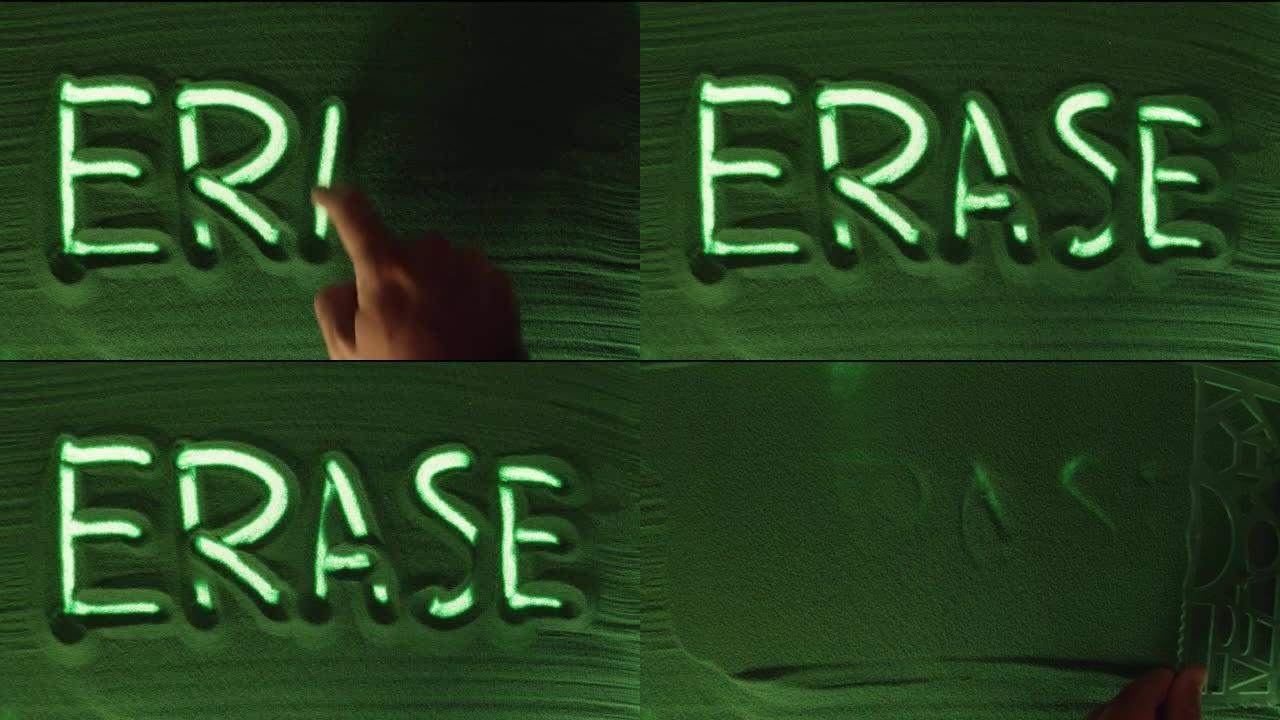 在绿色的沙子中手工绘制单词Erase，然后将其擦除。