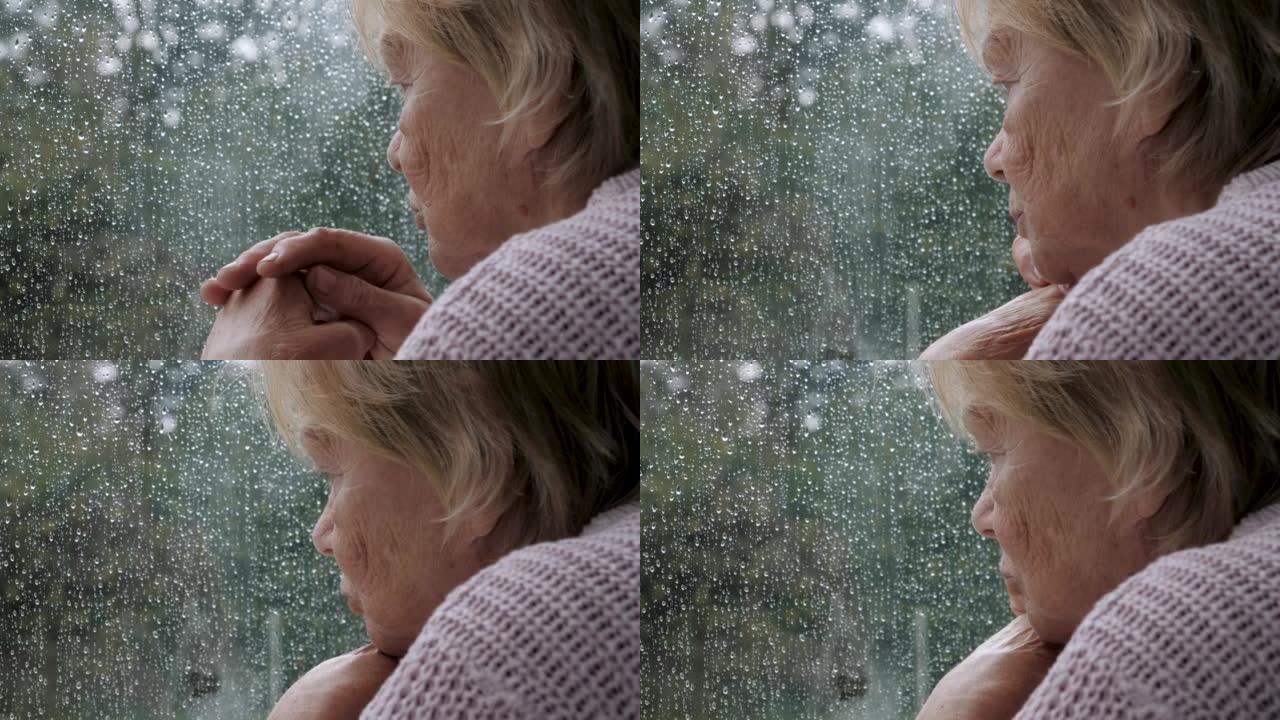 悲伤的老妇希望在雨中走出窗外