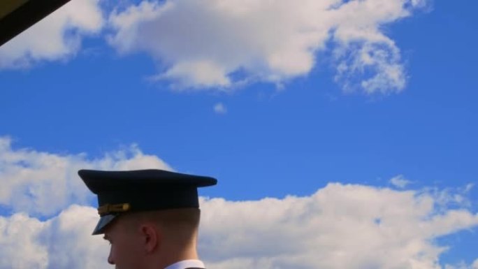机场，飞行员，飞机。穿着制服的自信男飞行员的肖像。在直升机飞行的天空背景下戴着帽子的机长。机场的直升