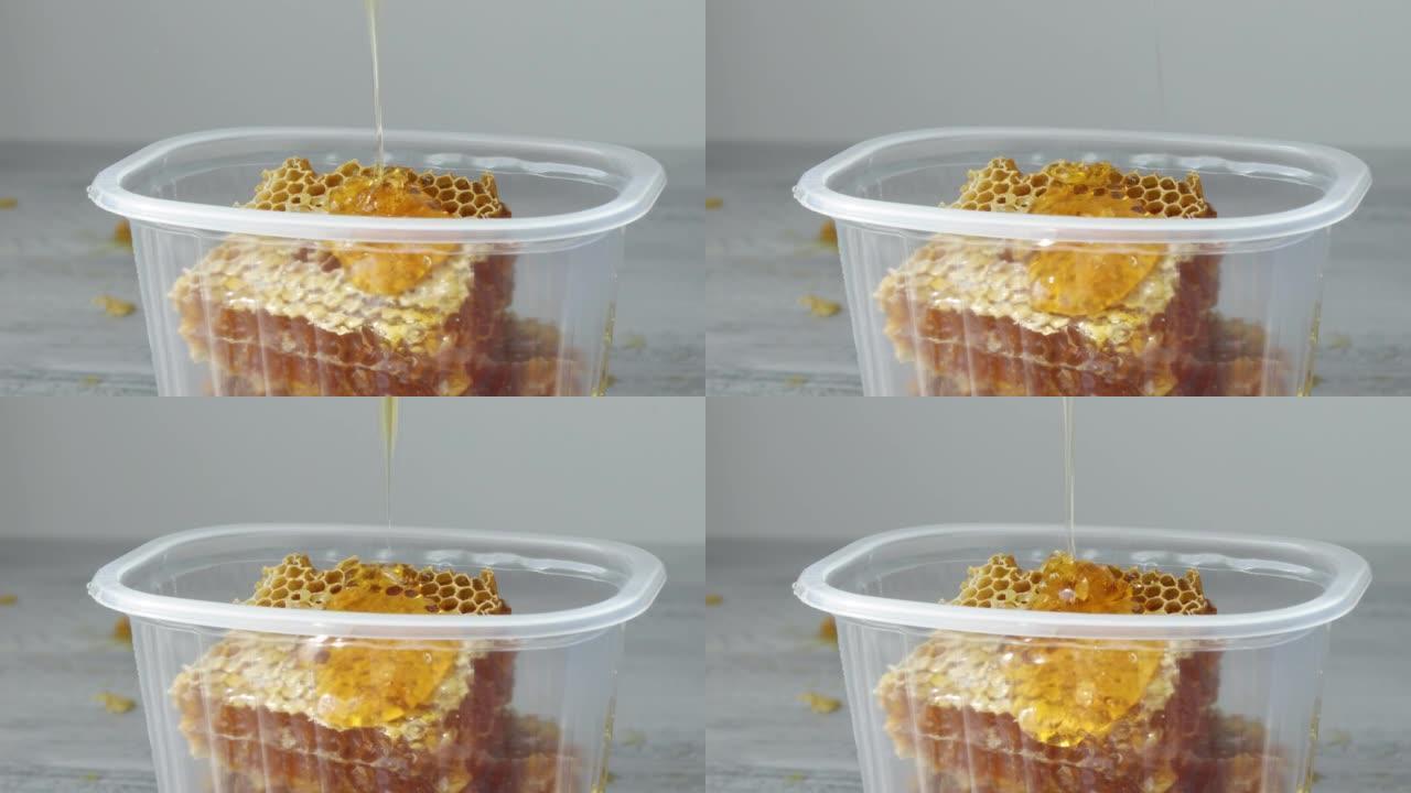 将蜂蜜滴在塑料容器中的甜蜂窝碎片上