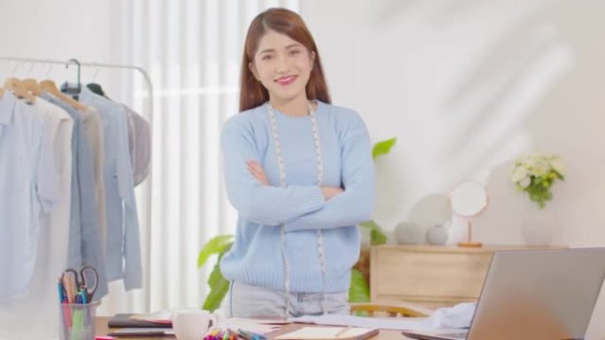 站在办公桌上的亚洲女性自由职业者设计师或造型师微笑双臂自信幸福情感。开朗的美丽的企业主企业家女性看相