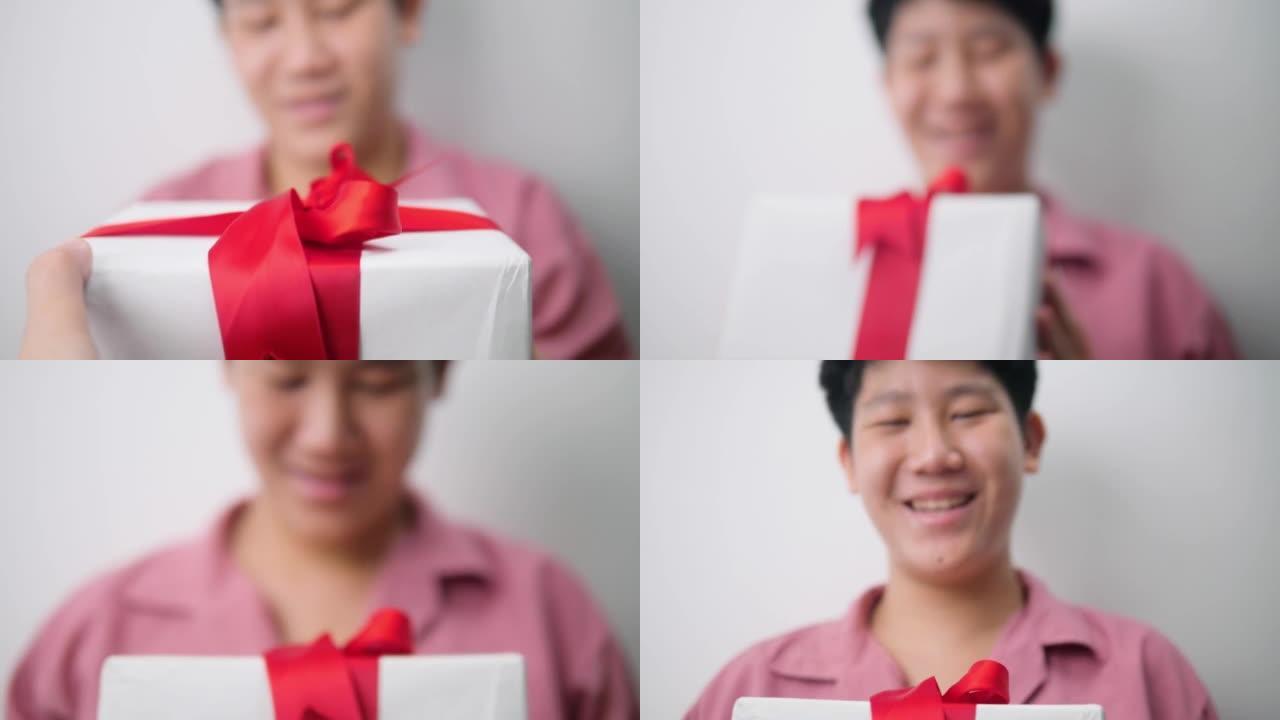 手给灰色背景的少年男孩白色礼品盒。