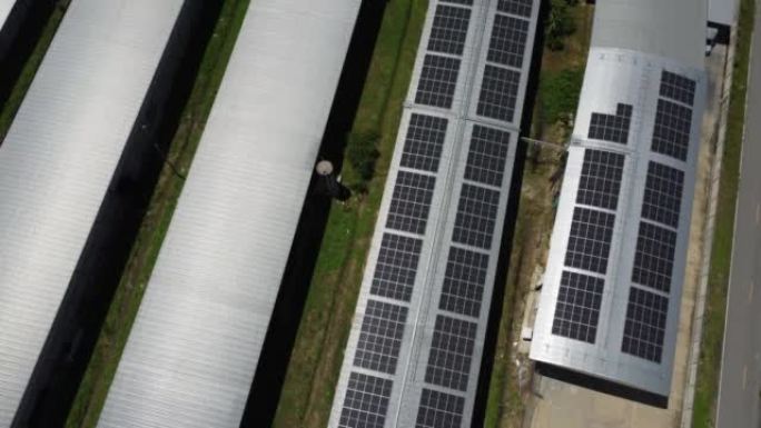 安装在大型工业建筑或仓库屋顶上的太阳能电池板的鸟瞰图。带工厂的太阳能发电站的俯视图。可持续能源概念。