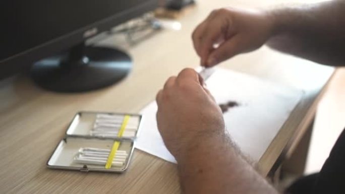 男性在制作自制香烟时用烟草填充卷纸