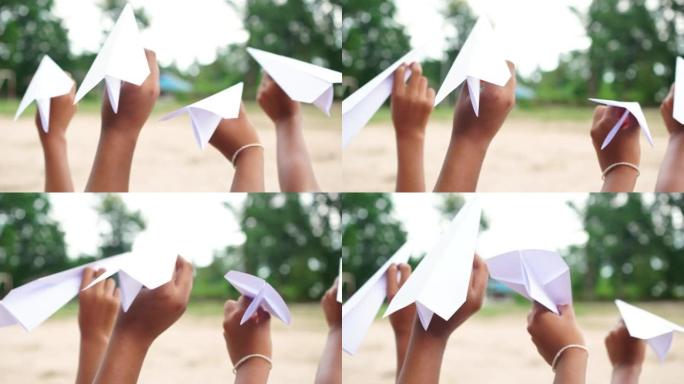 女孩玩由纸制成的有趣的飞机，创意，天然材料制成的玩具
