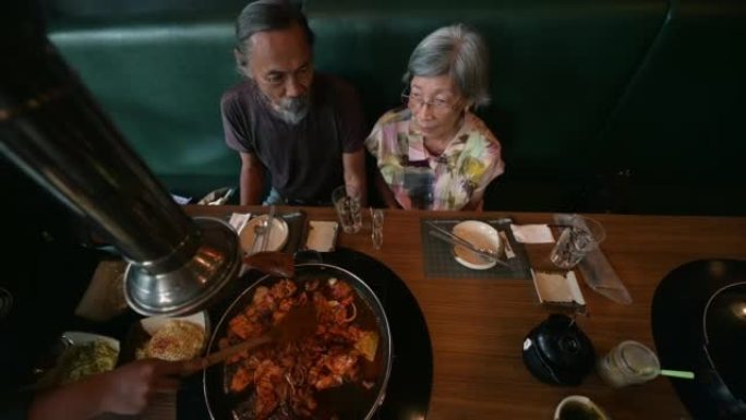 亚洲退休夫妇在美食广场吃韩国美食