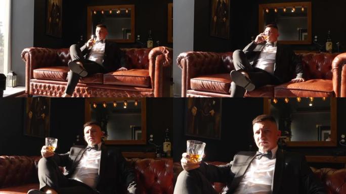 一个专横的有钱人穿着西装，打着领结，坐在皮沙发上喝着一杯威士忌。自信专横的新郎在婚礼上摆姿势。