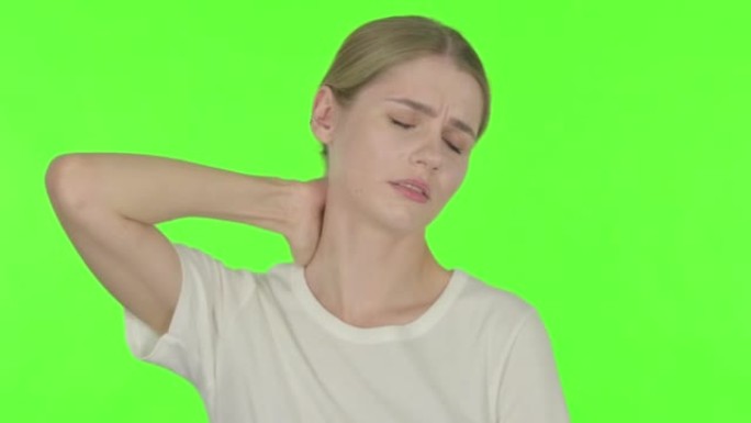 绿色背景下颈部疼痛的年轻女子