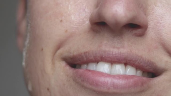 微笑的女人涂在脸上的热水美容护肤