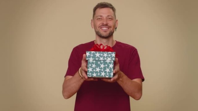 Handsome man presenting birthday gift box, offer w