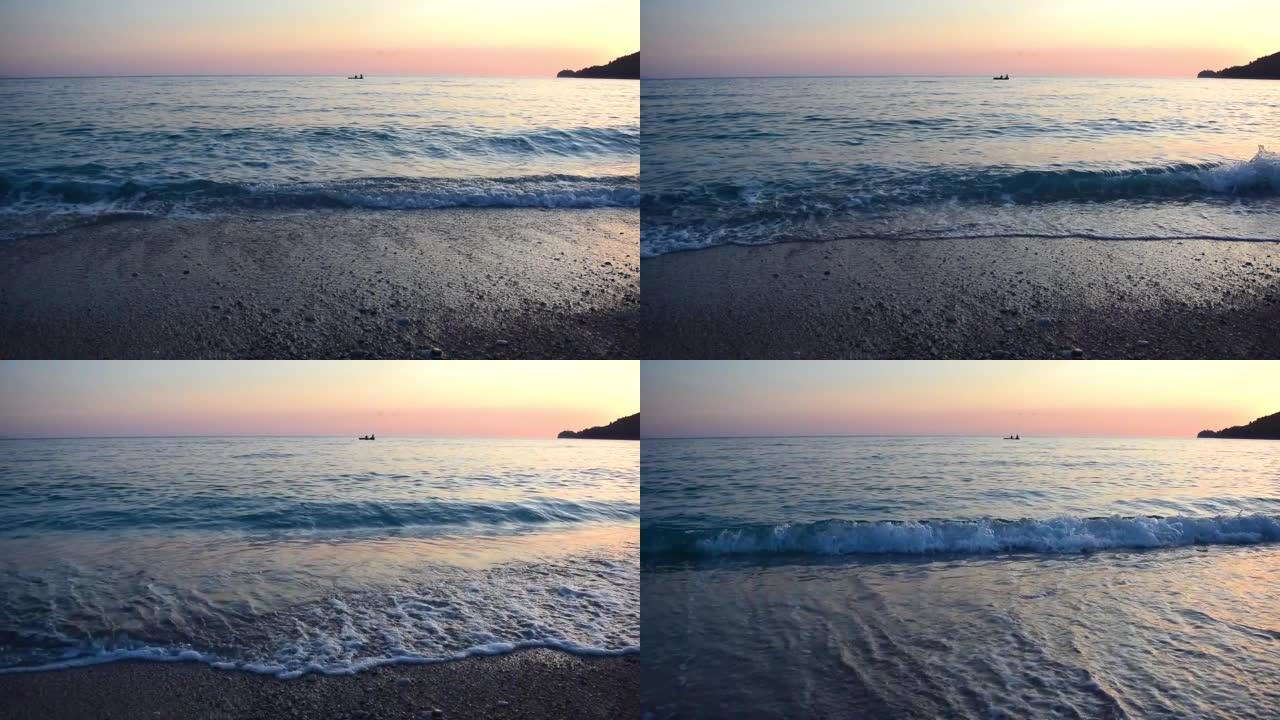 平静的海面在前景中冲浪，一艘小船和两个渔民在粉红色的日落天空中冲浪。