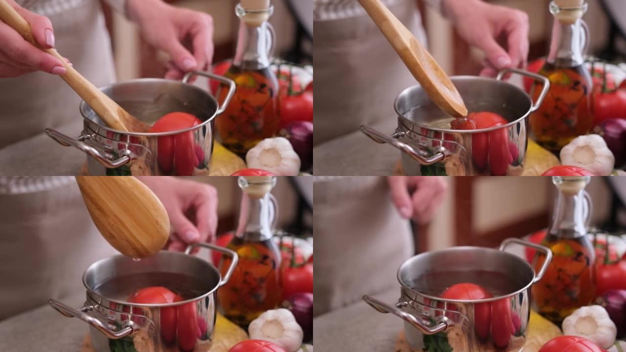 女人用热开水在锅里烫番茄