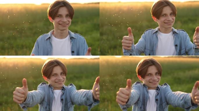 积极的青少年男子微笑着对着镜头，并在日落时在户外展示拇指。青春与积极情感观念