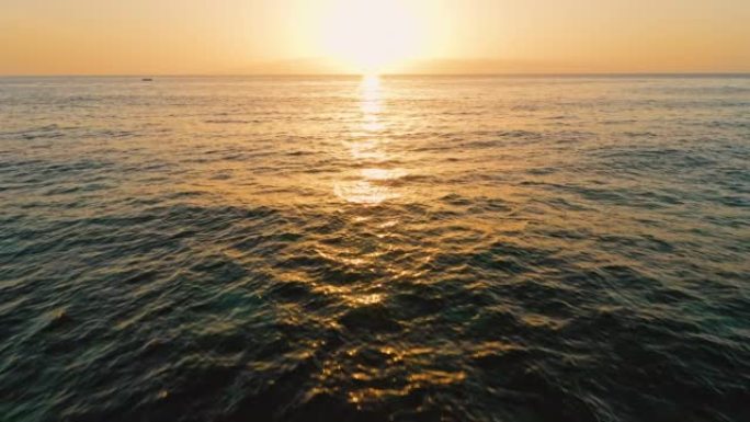 海上美丽的日落。金色清澈海洋咸水表面的太阳路径。晚上的风景。波浪起泡。天堂梦幻岛。无人机飞往太阳。