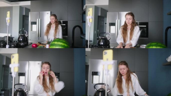 食物博主女人在厨房工作室烹饪新鲜的蔬菜素食沙拉，并在视频频道的智能手机上拍摄社交媒体内容的有趣舞蹈。