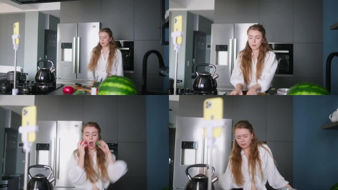 食物博主女人在厨房工作室烹饪新鲜的蔬菜素食沙拉，并在视频频道的智能手机上拍摄社交媒体内容的有趣舞蹈。