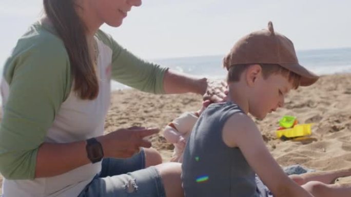 Mother applying sun protection on her children