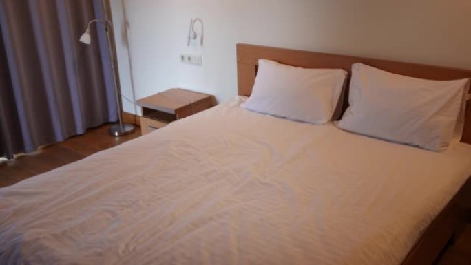 酒店室内高角度视角舒适软床。旅游胜地家具上舒适干净的床上用品，没有人。卫生和旅游概念。