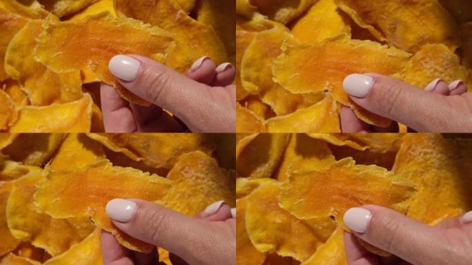 芒果干切片特写在白色上。顶视图。特写。芒果薯片背景。脱水脆皮水果片、片。一堆晒干的黄色水果。健康餐。