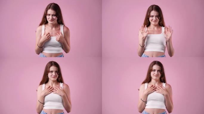 4k视频的女孩谁把她的手放在她的胸部粉红色的背景。
