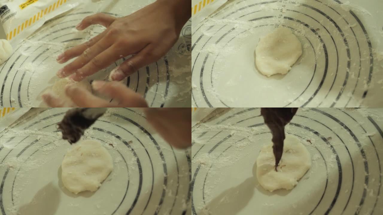 女孩的手在家里的厨房里用智能手机制作视频烹饪巧克力大福Mochi (日本小吃)，生活方式概念。