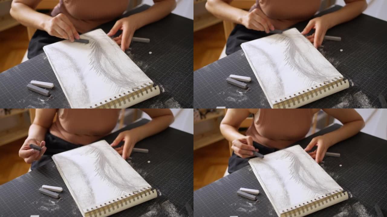 无法辨认的高加索艺术家在素描板上用木炭绘画