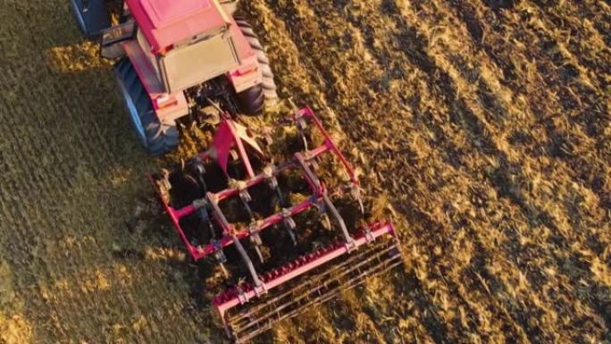 收割小麦收割后大型农业农场用旋耕犁拖拉机耕田的鸟瞰图